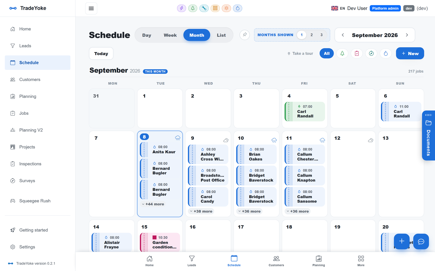 TradeYoke schedule, month view: jobs across six trades colour-coded, with day, week and list views
